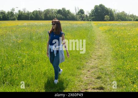 Eton, Windsor, Berkshire, Regno Unito. 12 maggio 2024. Una donna cammina attraverso un campo di tazze in una bella giornata di sole a Eton, Windsor, Berkshire. Si prevede che le temperature raggiungano di nuovo i 27 gradi oggi, tuttavia i temporali sono previsti più tardi. Crediti: Maureen McLean/Alamy Live News Foto Stock