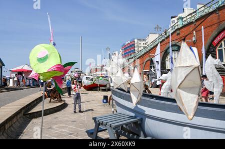 Brighton Regno Unito 12 maggio 2024 - i visitatori godono del caldo sole sulla spiaggia e sul lungomare di Brighton, dato che le temperature si prevedono oggi di raggiungere i 27 gradi in alcune zone del Sud Est. Accreditamento Simon Dack / Alamy Live News Foto Stock