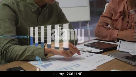 Immagine di grafici, globo, linguaggio informatico su diversi colleghi che analizzano i report in ufficio Foto Stock