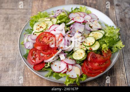 Un piatto di verdure fresche tritate condite con olio d'oliva e spezie. Piatto vegetariano. Insalata di verdure fresche in stile rustico. Messa a fuoco selettiva, Chiudi Foto Stock