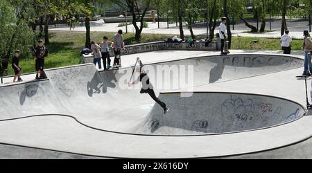 Kiev, Ucraina 27 aprile 2024: I ragazzi cavalcano skateboard e scooter nello Skate Park Foto Stock