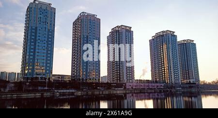 Kiev, Ucraina 1 marzo 2024: Edifici alti della città si riflettono nell'acqua del canale nella città di Kiev Foto Stock