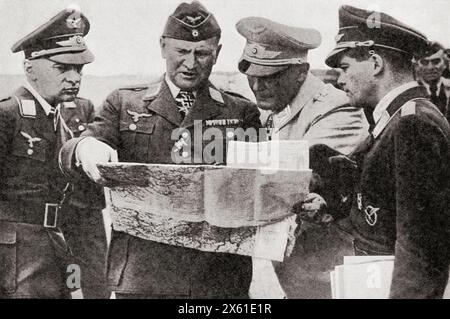 Goering con, a sinistra, il generale Jeschonnek, e a destra, il generale Loerzer, studio di una mappa mentre pianifica un attacco alla Gran Bretagna, 1940. Hermann Wilhelm Göring o Goering, 1893-1946. Politico tedesco, capo militare e criminale di guerra condannato. Hans Jeschonnek, 1899 – 1943. Aviatore militare tedesco nel Luftstreitkräfte durante la prima guerra mondiale Bruno Loerzer, 1891 - 1960. Ufficiale dell'aeronautica militare tedesca durante la prima e la seconda guerra mondiale dalla Guerra in immagini, sesto anno. Foto Stock