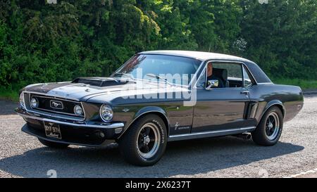 Stoke Goldington, Regno Unito - 12 maggio 2024: 1970 Ford Mustang auto d'epoca che guida su una strada britannica Foto Stock