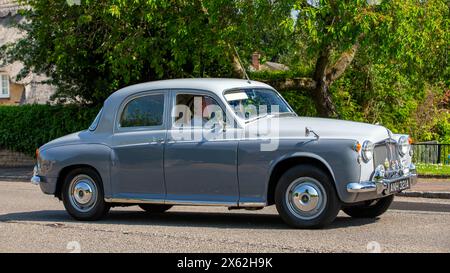 Stoke Goldington, Regno Unito - 12 maggio 2024: 1957 Morris Oxford auto d'epoca che guida su una strada britannica Foto Stock