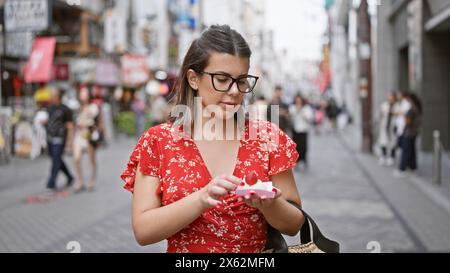 Splendida ragazza ispanica in cerca di mochi giapponesi alla fragola nella famosa via dotonbori di osaka Foto Stock