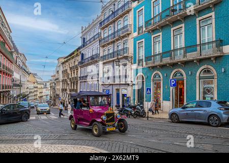 LISBONA, PORTOGALLO - 5 APRILE 2024: Funny Electric car chiamata Tuk-Tuk Car che simboleggia un'auto d'epoca, utilizzata per il trasporto turistico sulla strada della città Foto Stock