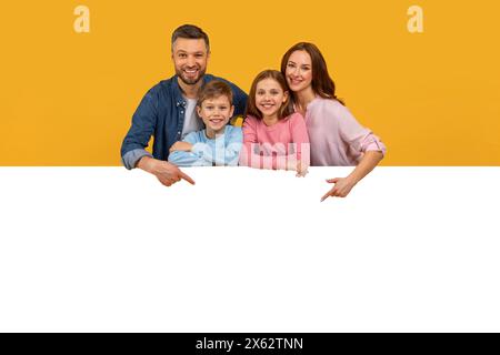 Smiling Family of Four in posa con un enorme Blank Board Foto Stock