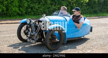 Stoke Goldington, Regno Unito - 12 maggio 2024: 1932 Morgan Super Sport classica auto a tre ruote blu che guida su una strada britannica Foto Stock