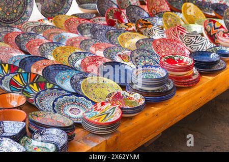 Piatti e ciotole uzbeke colorati fatti a mano con motivi tradizionali sono messi in vendita in un mercato di strada a Bukhara Foto Stock