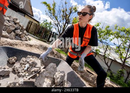 Hostomel, Kyjiw Oblast, Ucraina. 11) mai 2024. Freiwillige der Organisation coraggioso a ricostruire arbeiten am Abriss und dem Wiederaufbau von Häusern, die zu Beginn der Invasion der Ukraine a Hostomel, in der Nähe der Hauptstadt Kyjiw, durch das russische Militär zerstört wurden. Oblast' di Kiev *** Hostomel, Oblast' di Kiev, Ucraina 11 maggio 2024 volontari dell'organizzazione coraggiosi a ricostruire i lavori di demolizione e ricostruzione di case distrutte dai militari russi all'inizio dell'invasione dell'Ucraina a Hostomel, vicino alla capitale Kiev Oblast' di Kiev Foto Stock