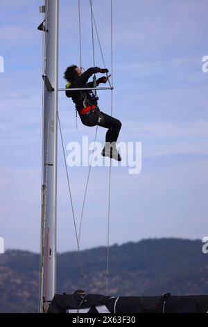 Bodrum, Turchia. 25 febbraio 2024: Giovane impiccato e ripara l'albero dello yacht High Up Stock Photo Foto Stock