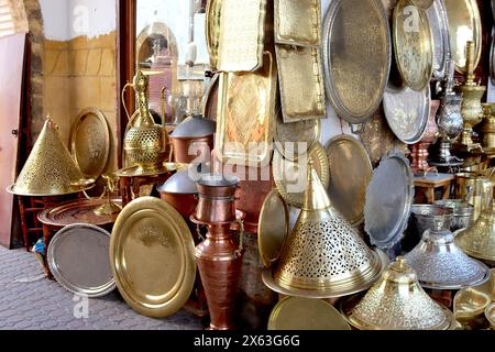 Mercato marocchino che vende oggetti decorati in ottone, rame e argento; vassoi, piatti, teiere, piatti, piatti, lampade da tavolo, lampade da terra Layla. Foto Stock