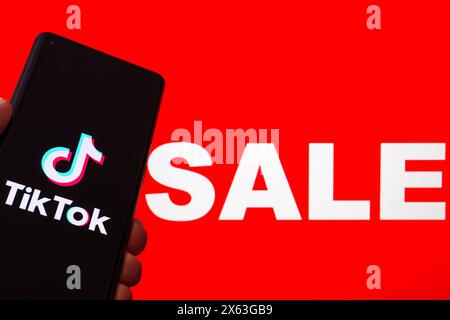 App TikTok su smartphone con un vivace background di vendita - Marketing e Social Media Concept. Stafford, Regno Unito, 28 aprile 2024 Foto Stock