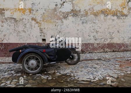 265 motocicletta nera sidecar Dnepr KMZ-MT-10-36 di fabbricazione sovietica parcheggiata nel tardo pomeriggio in Calle Alameda Street inondata da acqua pulente. Trinidad-Cuba. Foto Stock