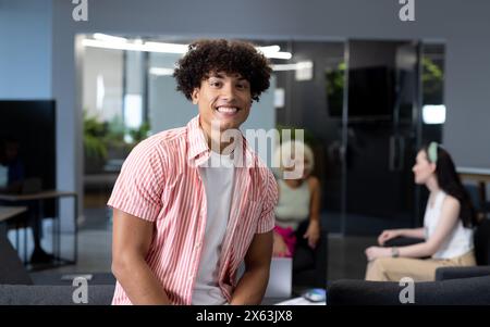 In un ufficio moderno, un team giovane e diversificato che discute con uno sfondo blu Foto Stock