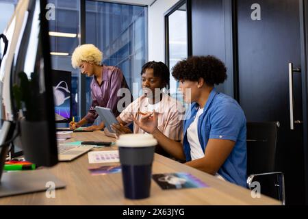 In un ufficio moderno, un team giovane e diversificato collabora Foto Stock