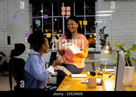 Lavorare fino a tardi, diverse colleghe d'affari discutono di lavoro Foto Stock