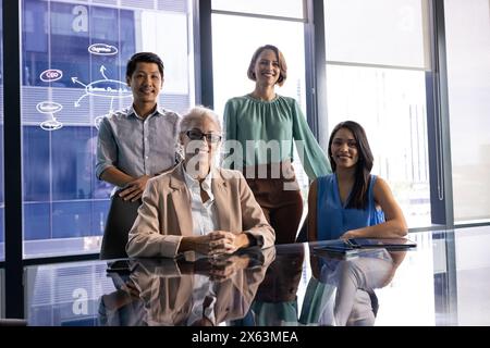 In ufficio, diversi team si riuniscono intorno a un tavolo di vetro Foto Stock