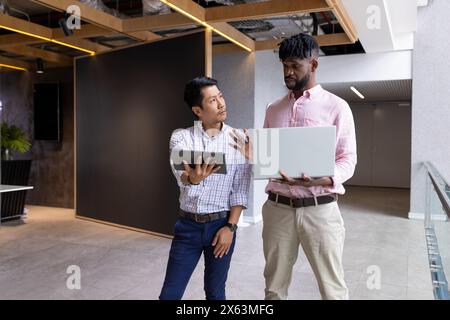 Team diversificato che discutono progetti in ufficio, indossando un abbigliamento casual elegante Foto Stock