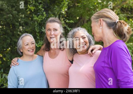 All'aperto, diverse amiche anziane in piedi insieme, sorridenti Foto Stock