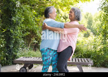 All'aperto, diverse amiche di sesso femminile che accolgono calorosamente Foto Stock