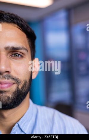 Birazziale professionale con barba in stecche per camicie a righe blu in ufficio, spazio copie Foto Stock