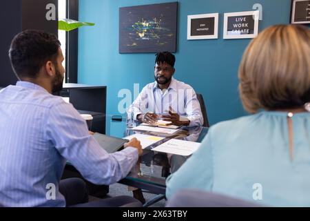 Team eterogenei che discutono di affari in un ufficio moderno Foto Stock
