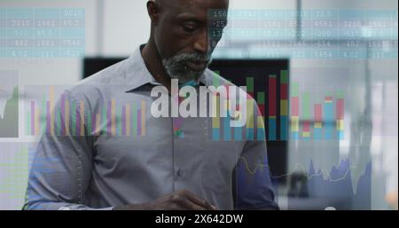 L'immagine di un uomo afroamericano di mezza età in camicia esamina i dati finanziari Foto Stock