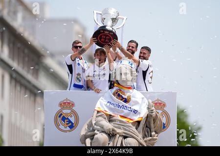 Toni Kroos, Luka Modric, Nacho Fernandez e Daniel Carvajal festeggiano in cima alla fontana con il trofeo durante la celebrazione del Real Madrid a Plaza de Cibeles per il loro 36° titolo del campionato spagnolo il 12 maggio 2024 a Madrid, Spagna Foto Stock