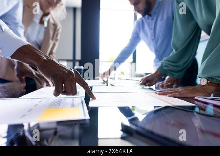 Team diversificato che discutono documenti aziendali in ufficio Foto Stock