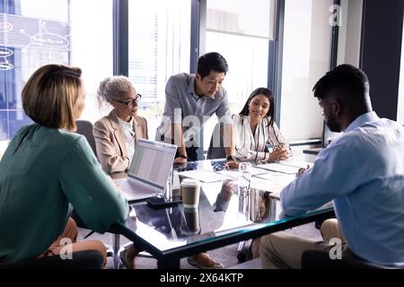 Team diversificato che discutono documenti aziendali in ufficio Foto Stock