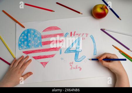 Le mani del bambino dipingono la bandiera americana su un tavolo bianco. Disegno per bambini della bandiera d'America. Giorno dell'indipendenza, 4 luglio. Foto di alta qualità Foto Stock