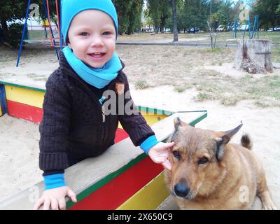 bambino di otto anni dai capelli rossi con un grande barboncino reale nella foresta autunnale. Foto di alta qualità Foto Stock