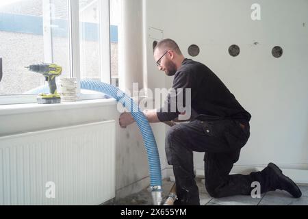 Installazione di isolamento interno in fibra di cellulosa soffiata in una casa in Scozia Foto Stock