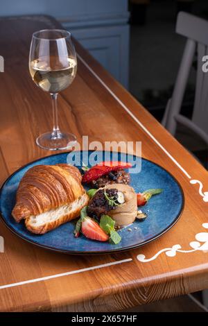 Croissant appena sfornato con patè di fegato, gustoso antipasto gourmet sul tavolo Foto Stock