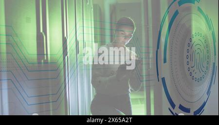 Immagine dell'impronta digitale su una donna caucasica che utilizza un tablet digitale nella sala server Foto Stock