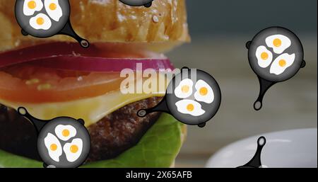 Un hamburger con uova che galleggiano attorno ad esso poggia sul piatto Foto Stock