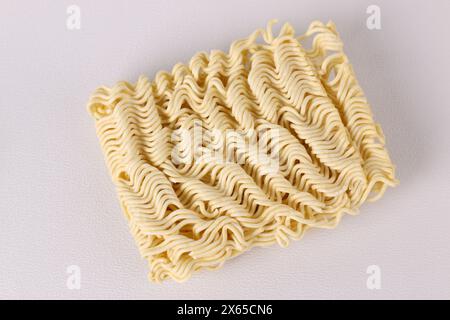 Ramen di tagliatelle istantanee crude asciutte con sfondo bianco. Cibo malsano. Foto Stock