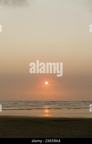 Il sole tramonta sull'orizzonte dell'oceano Foto Stock