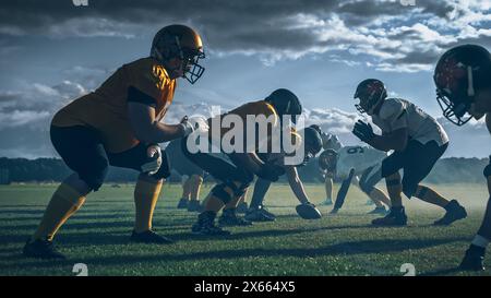 Due squadre professioniste di football americano si trovano di fronte all'altra, pronte a iniziare la partita. Difesa e attacco preparati a combattere per il pallone con il desiderio di segnare punti e il gol e vincere. Foto Stock