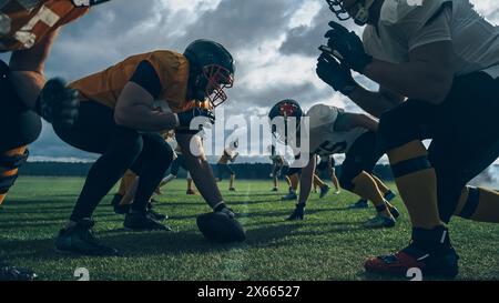 Due squadre professioniste di football americano si trovano di fronte all'altra, pronte a iniziare la partita. Difesa e attacco preparati a combattere per il pallone con il desiderio di segnare punti e il gol e vincere. Foto Stock