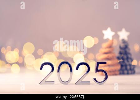 Numeri metallici 2025 su un tavolo bianco con alberi di Natale e luci bokeh. Il concetto di felice anno nuovo 2025 sta arrivando. Foto Stock