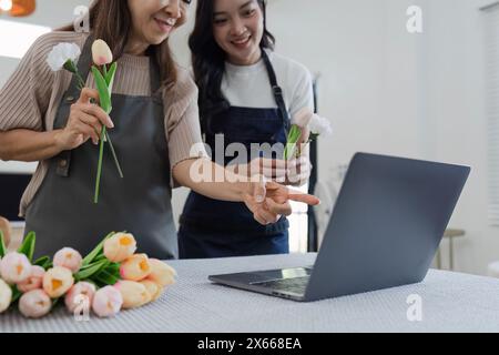 madre e figlia organizzano i fiori insieme come hobby. madre e figlia trascorrono del tempo libero a fare fiori organizzando attività insieme e guardando Foto Stock