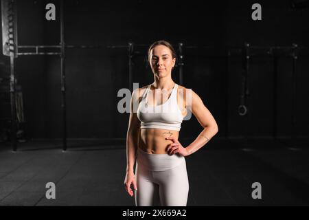 Ritratto di una giovane donna muscolare in palestra. Allenamento di routine per la salute fisica e mentale. Foto Stock