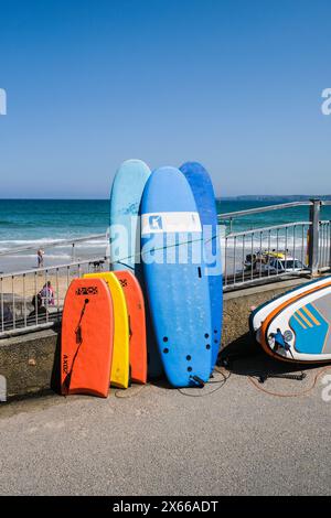 Tavole da surf e bodyboard boogie board disponibili a noleggio presso Towan Beach a Newquay in Cornovaglia nel Regno Unito. Foto Stock