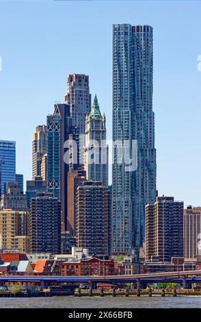 8 Spruce Street, precedentemente conosciuta come New York da Gehry, domina questa vista del quartiere finanziario, visto dal Brooklyn Bridge Park. Foto Stock