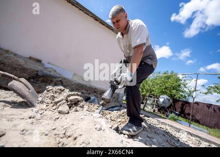 Hostomel, Kyjiw Oblast, Ucraina. 11) mai 2024. Freiwillige der Organisation coraggioso a ricostruire arbeiten am Abriss und dem Wiederaufbau von Häusern, die zu Beginn der Invasion der Ukraine a Hostomel, in der Nähe der Hauptstadt Kyjiw, durch das russische Militär zerstört wurden. Oblast' di Kiev *** Hostomel, Oblast' di Kiev, Ucraina 11 maggio 2024 volontari dell'organizzazione coraggiosi a ricostruire i lavori di demolizione e ricostruzione di case distrutte dai militari russi all'inizio dell'invasione dell'Ucraina a Hostomel, vicino alla capitale Kiev Oblast' di Kiev Foto Stock