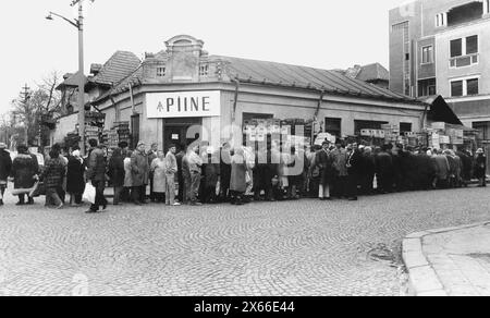 Bucarest, Romania, gennaio 1990. Meno di un mese dopo la rivoluzione anticomunista del dicembre 1989, la gente rimane ancora in lunghe file per ottenere la presa dei generi alimentari di base. Il sistema economico socialista centralizzato ha creato scarsità e fame. Qui, una linea di fronte a un negozio di pane. Foto Stock