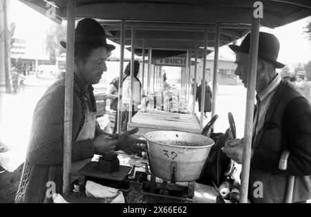 Repubblica Socialista di Romania negli anni '1970 Venditore e acquirente in un mercato agricolo in una piccola città. Foto Stock